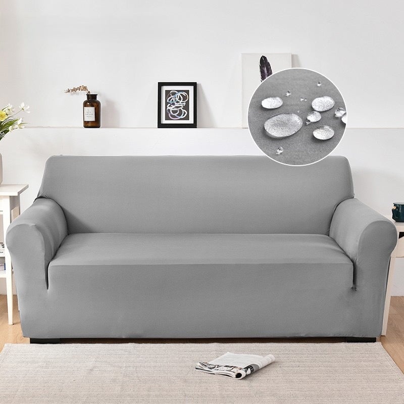 Ash grey water-resistant stretchable sofa cover, elastic fit, soft polyester-spandex texture, enhances home decor elegance.