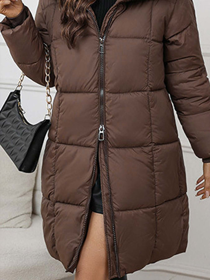 Women's long black puffer coat with hood, providing superior insulation & comfort.