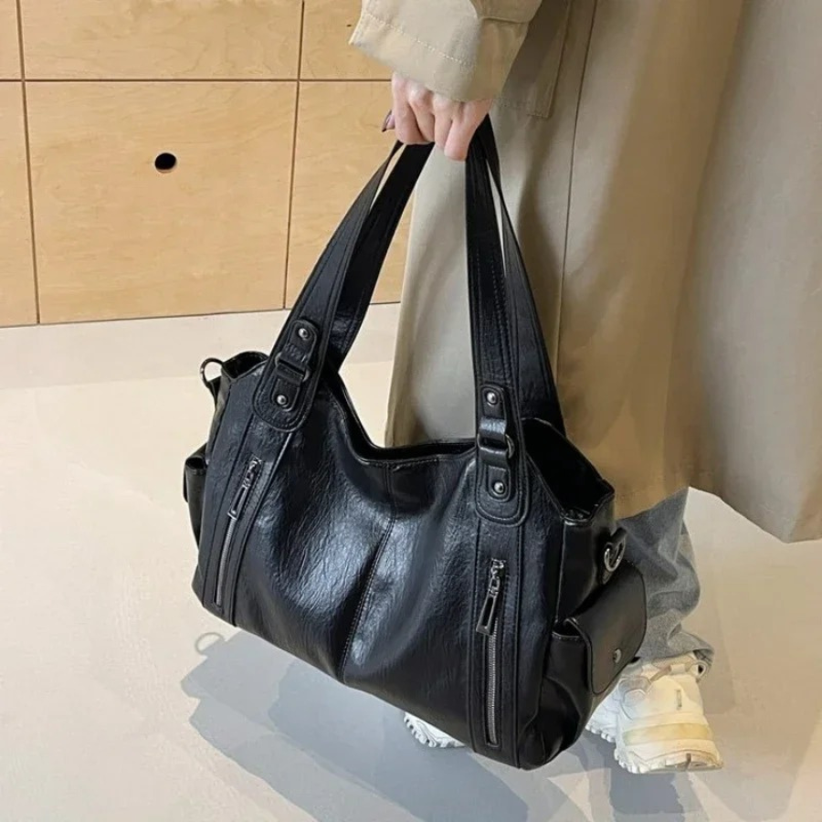 Black women's versatile faux leather shoulder duffle bag, perfect for everyday carry & travel.
