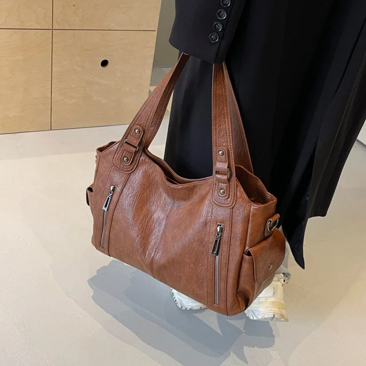Organized light brown women's faux leather duffle bag, a versatile shoulder bag for daily carry.
