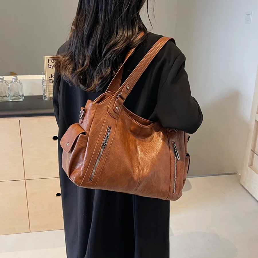 Women's stylish faux leather duffle bag in black, a practical shoulder bag for travel & daily use.