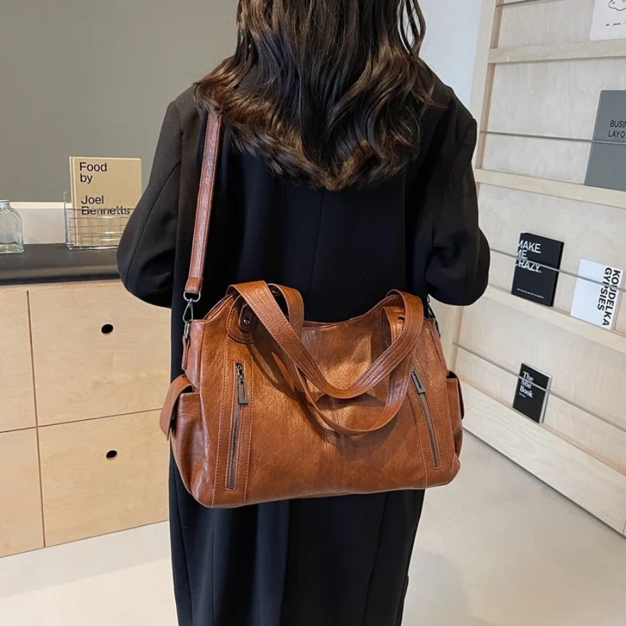 Brown faux leather women's shoulder duffle bag, a versatile accessory for travel & everyday carry.