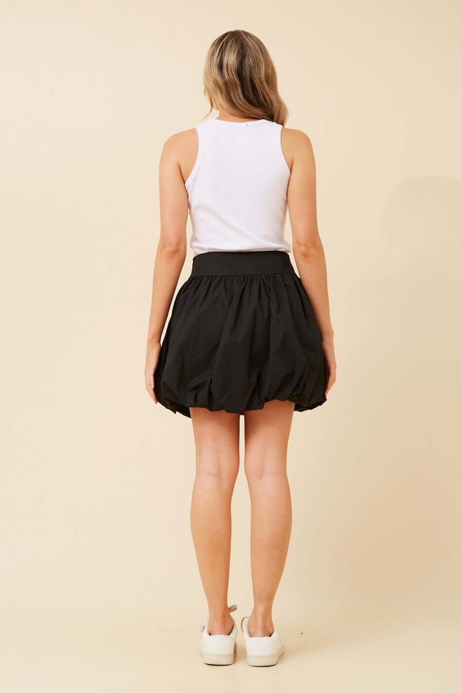Stylish black women's bubble mini skirt, offering a voluminous look and a sleek fitted waist for chic outfits.