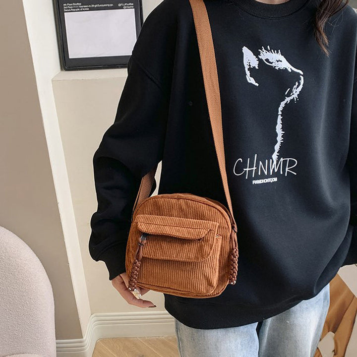 Black women's small crossbody bag with front zip pocket, perfect for hands-free essentials.