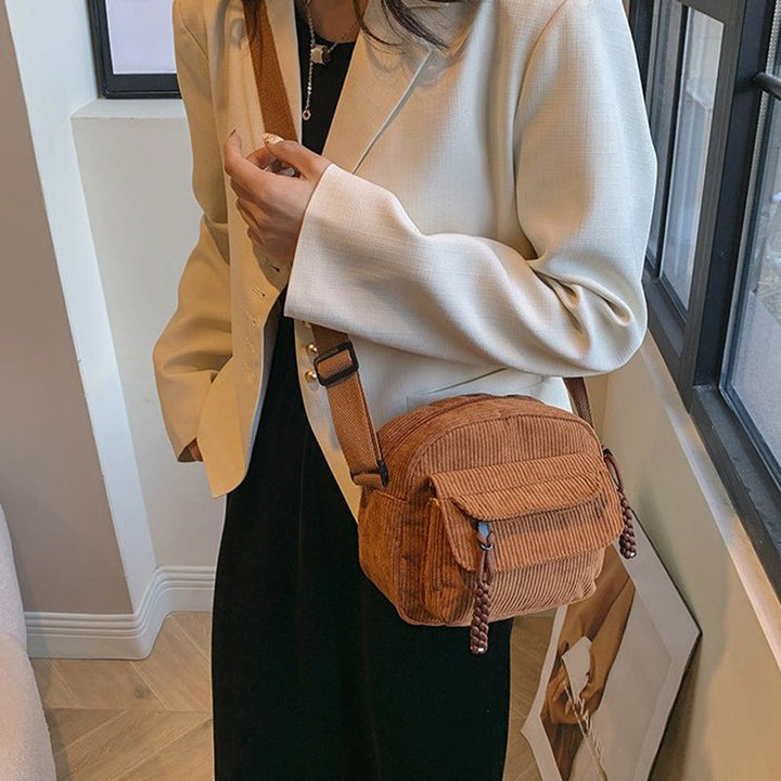 Sleek black vintage style small shoulder bag for women, featuring a practical front zip pocket.