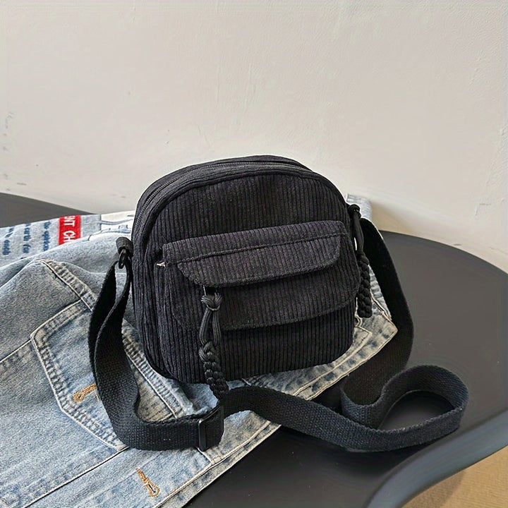 Hands-free black women's accessory: small crossbody bag with a convenient front zip pocket.