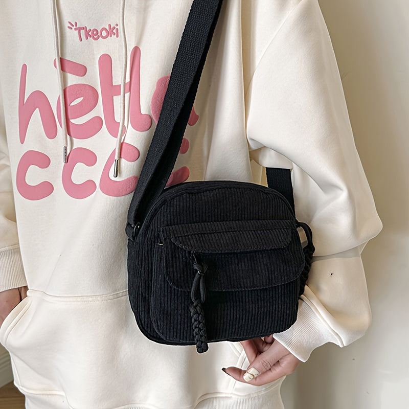 Stylish black women's small bag, crossbody design, with an accessible front zip pocket.