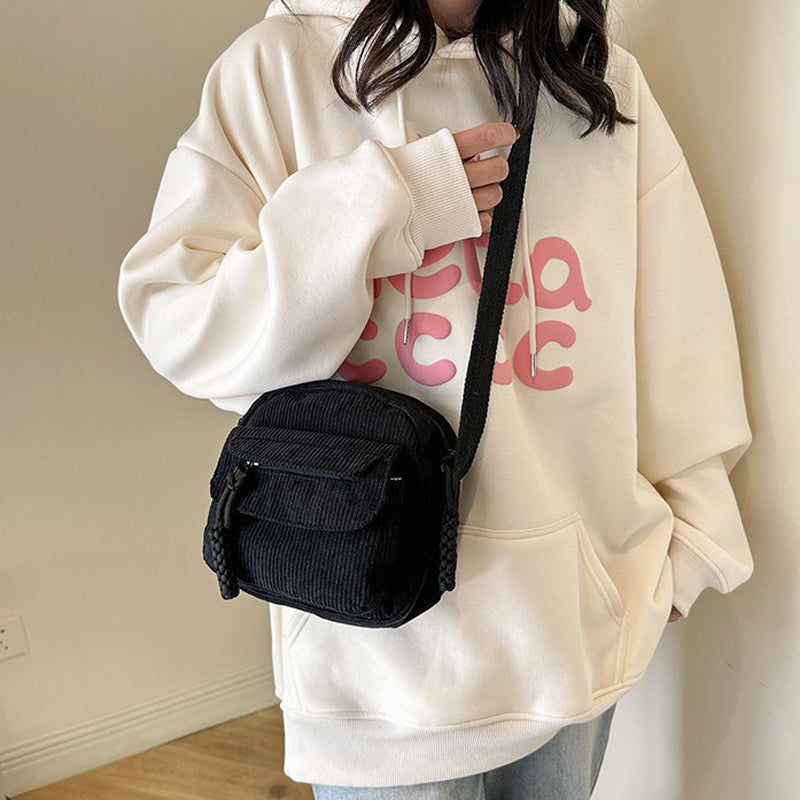 Jet black small crossbody bag for women, features a practical front zip pocket & adjustable strap.