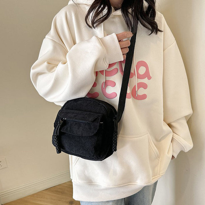 Jet black small crossbody bag for women, features a practical front zip pocket & adjustable strap.