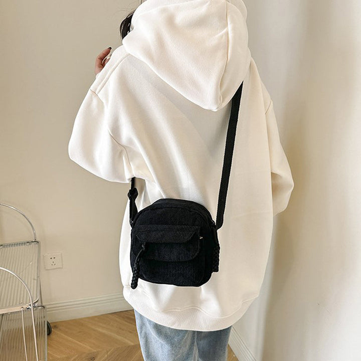 Beige women's small crossbody bag with front zip pocket, perfect for hands-free daily essentials.
