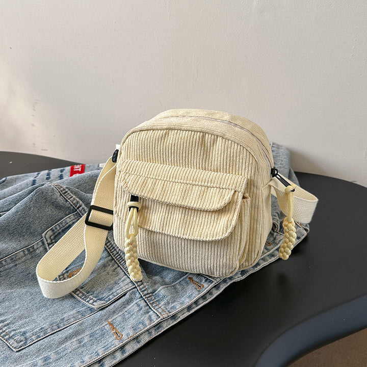 Hands-free beige women's accessory: small crossbody bag with a convenient front zip pocket.