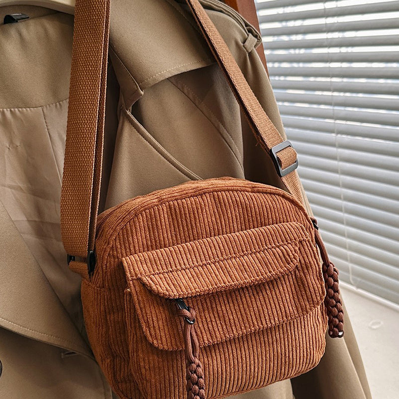 Compact brown daily essential women's crossbody bag with a secure front zip pocket.