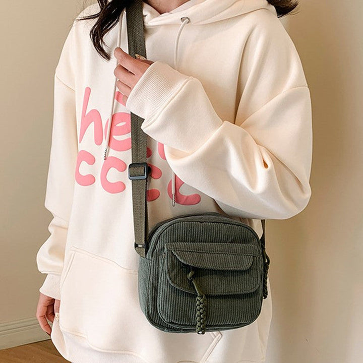 Hands-free green women's accessory: small crossbody bag with a convenient front zip pocket.
