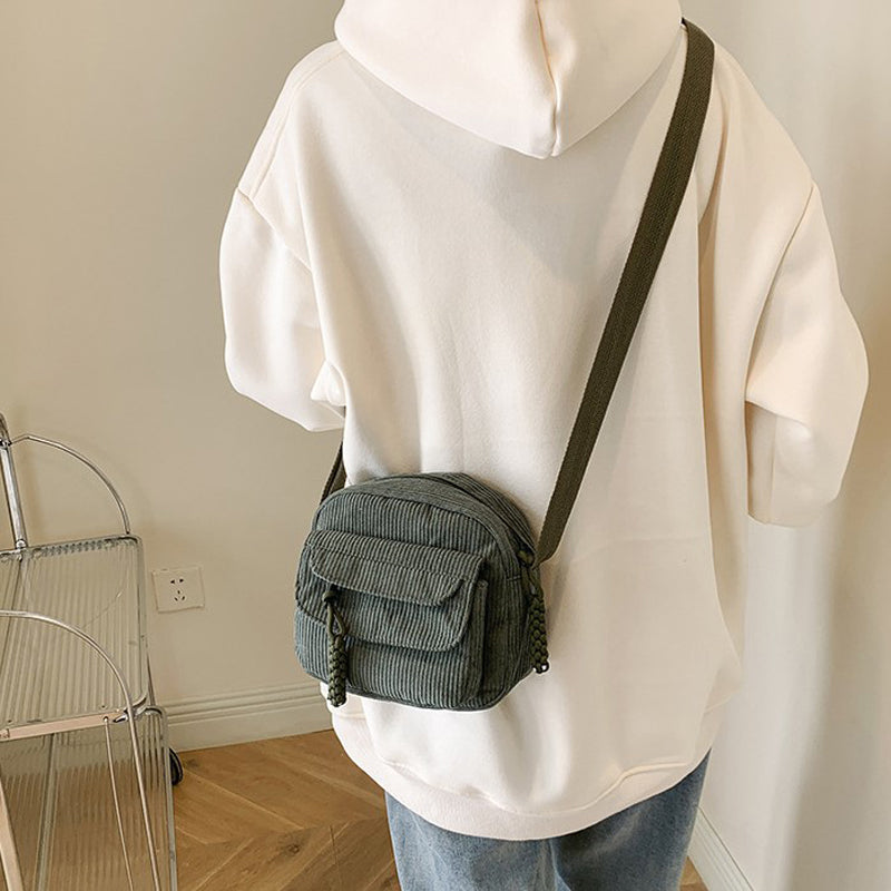 Green small shoulder bag for women, with a functional front zip pocket and adjustable strap.