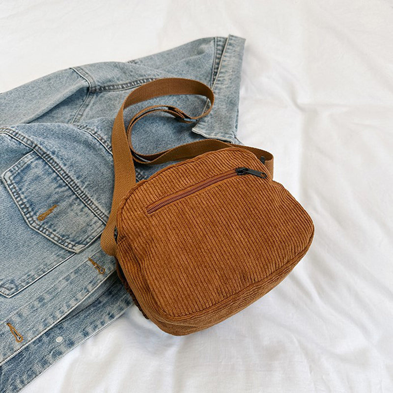 Brown small shoulder bag for women, with a functional front zip pocket and adjustable strap.