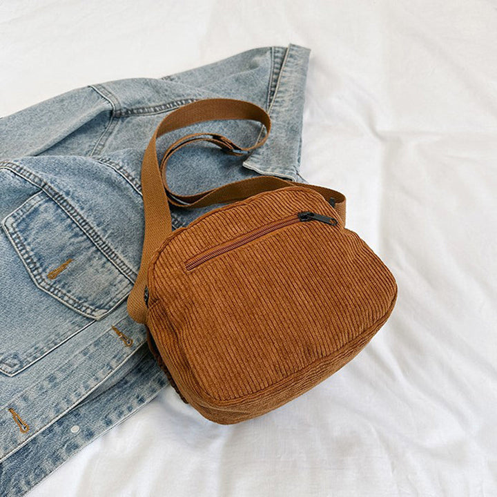 Brown small shoulder bag for women, with a functional front zip pocket and adjustable strap.