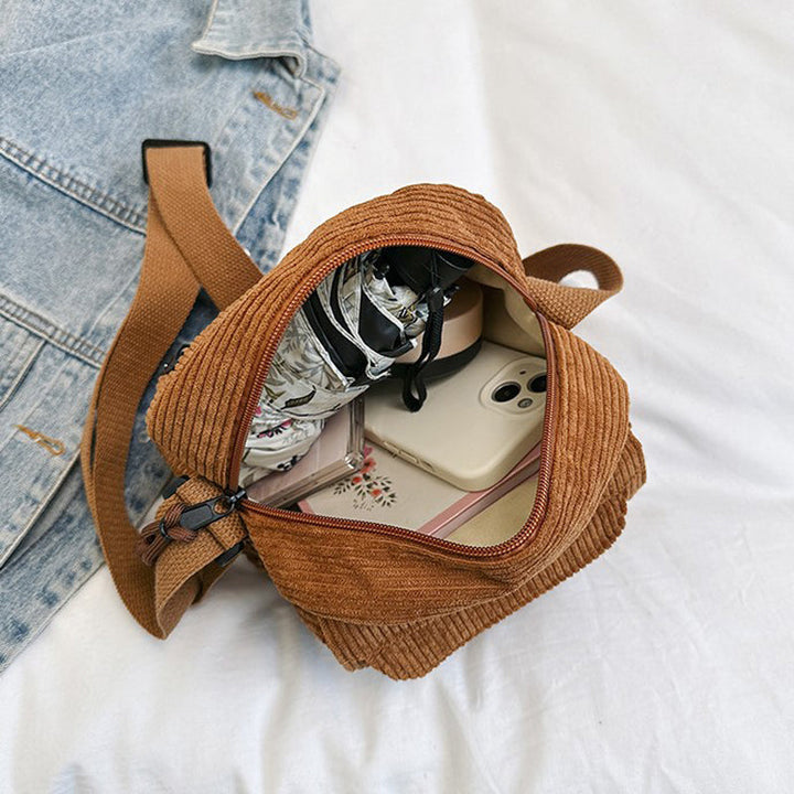 Dark brown small crossbody bag for women, features a practical front zip pocket & adjustable strap.