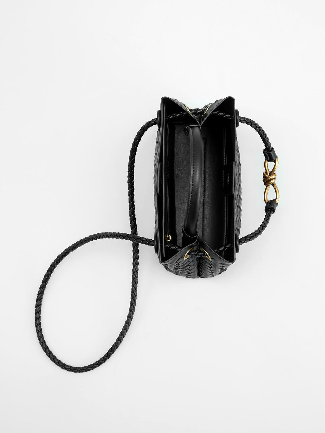 Versatile women's black woven top handle bag with a chic twist detail. An elegant, structured fashion accessory.