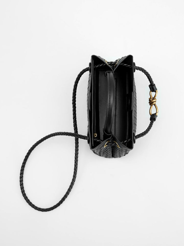 Versatile women's black woven top handle bag with a chic twist detail. An elegant, structured fashion accessory.