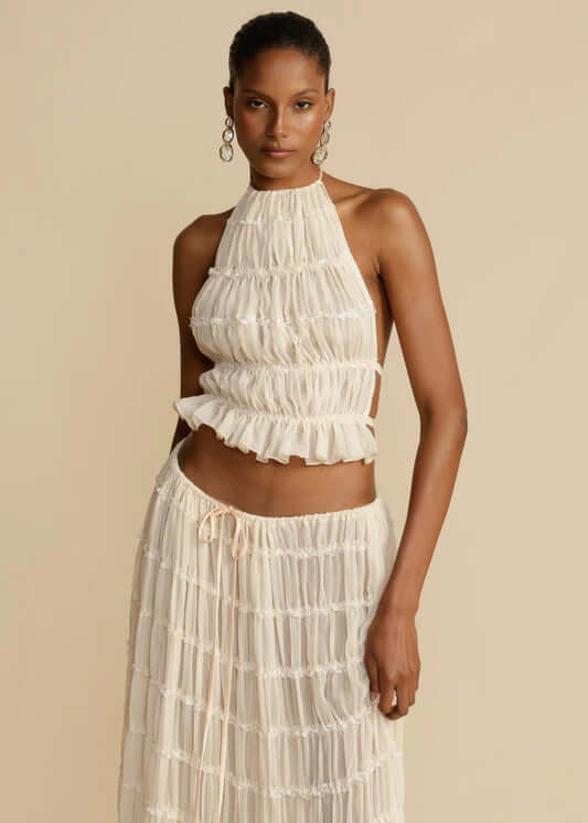 Chic white women's halter top and mini skirt set. Perfect two-piece summer fashion outfit for versatile wear.