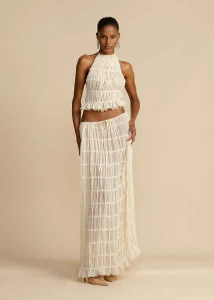 Elegant white women's two-piece set: a trendy halter top & a matching mini skirt, ideal for summer fashion.
