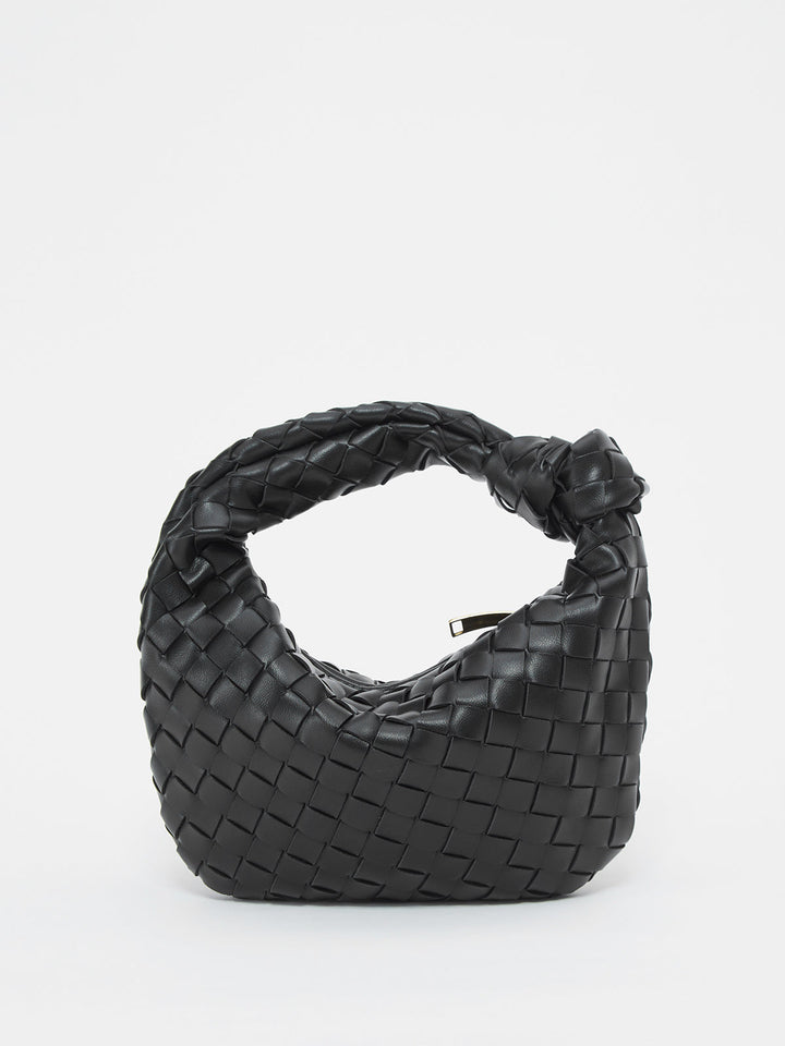 Textured women's shoulder bag with unique braided knot handle, a modern chic handbag statement.