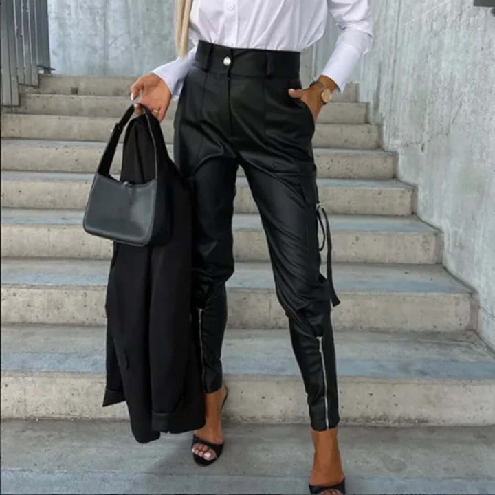 Black faux leather high-waisted cargo pants for women, featuring a tapered leg. Perfect for edgy streetwear fashion.