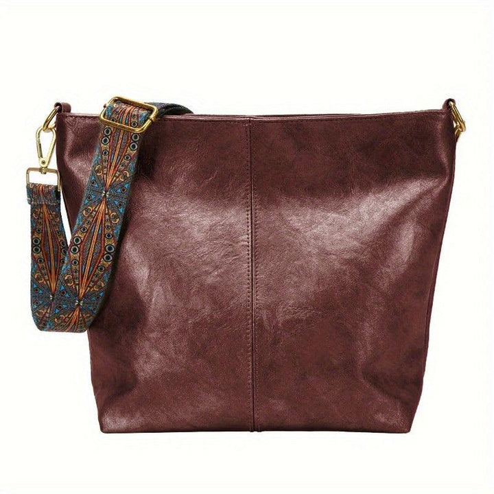 Fashionable women's handbag: faux leather with a unique embellished strap, perfect for shoulder or crossbody wear.