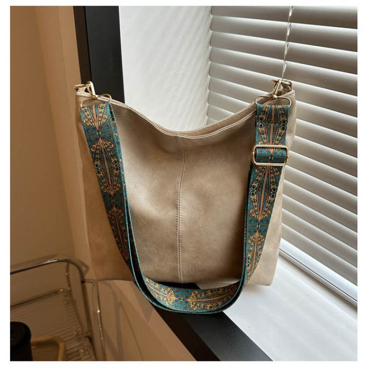 Chic women's faux leather shoulder bag in a vibrant green, accessorized with a unique and stylish embellished strap.