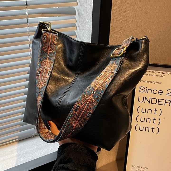 Textured faux leather women's shoulder bag in caramel, showcasing the material and elegant embellished strap.