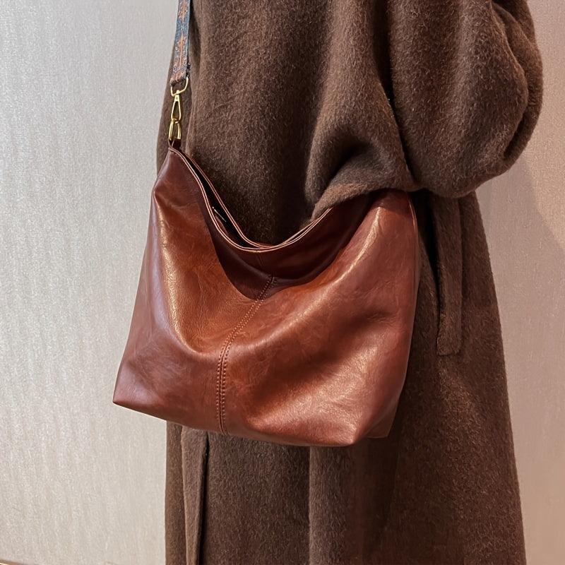 Versatile women's faux leather bag, wearable as a shoulder or crossbody bag, with a chic embellished strap.