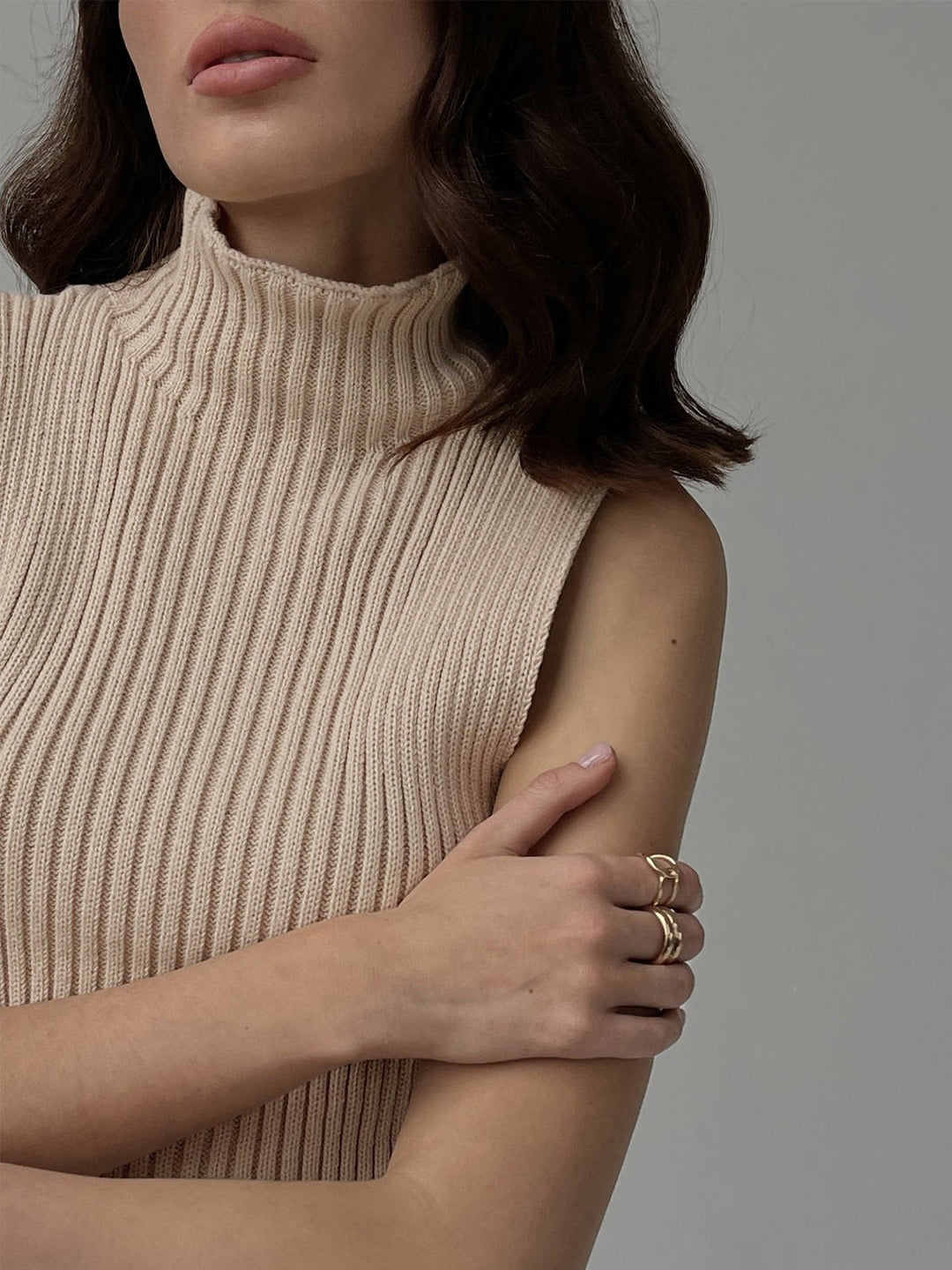 Close-up of a women's ribbed knit sleeveless top, showcasing the mock neck and textured fabric.