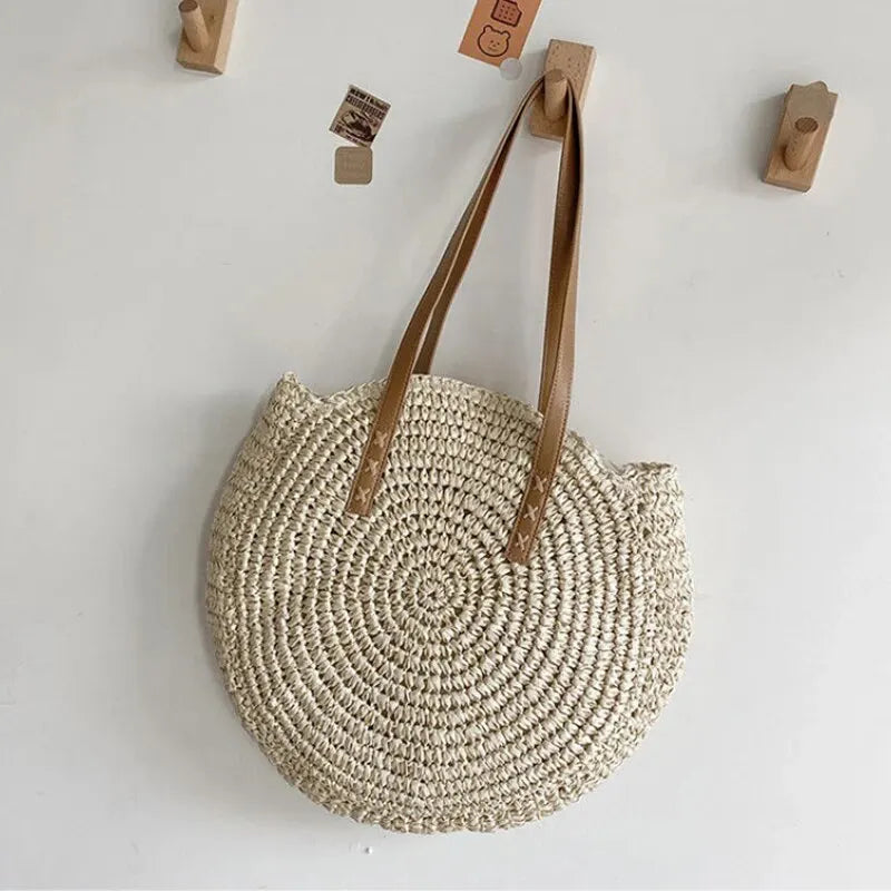 Women's natural round woven beach bag, a chic summer tote. Perfect for carrying essentials on vacation.
