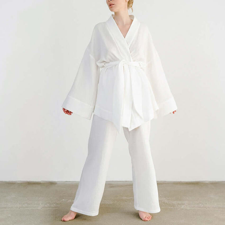 Women's versatile v-neck top & wide-leg trousers set with tie waist. Breathable style for elegant spring fashion.