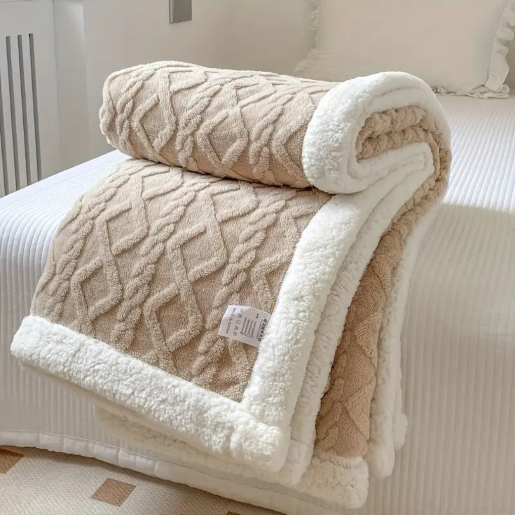 Close-up of the textured diamond knit pattern on a soft, reversible sherpa blanket, emphasizing its luxury.