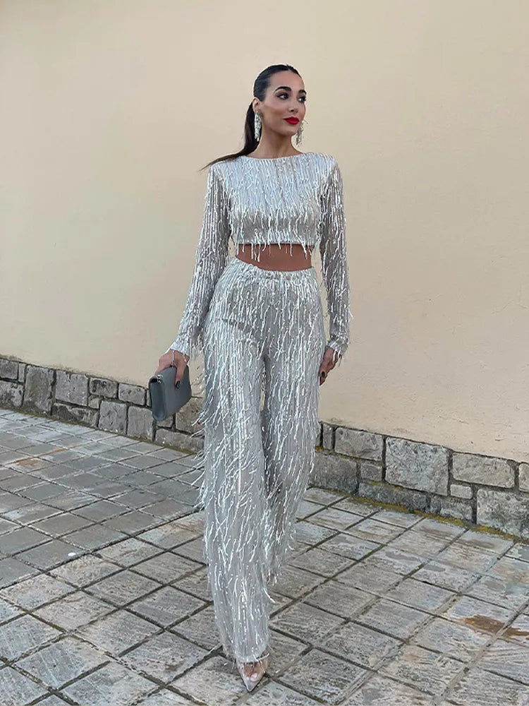 Shimmering women's sequin two-piece set. Elegant crop top & high-waisted fringe skirt, ideal for evening wear.