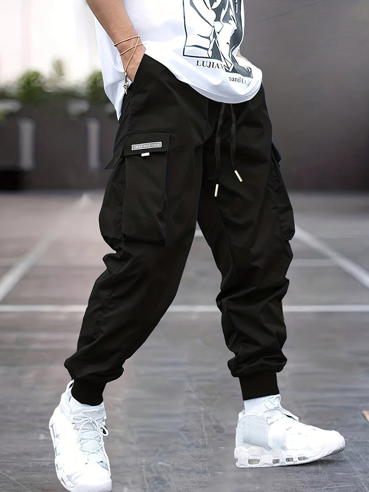 "Durable men's black cargo pants front view with multiple pockets, sleek modern fit, versatile style for urban adventures."