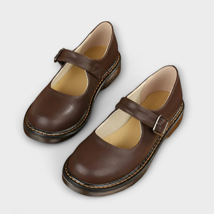 Elegant black leather Mary Jane shoes for women, featuring a classic strap design & low heel for office or formal wear.