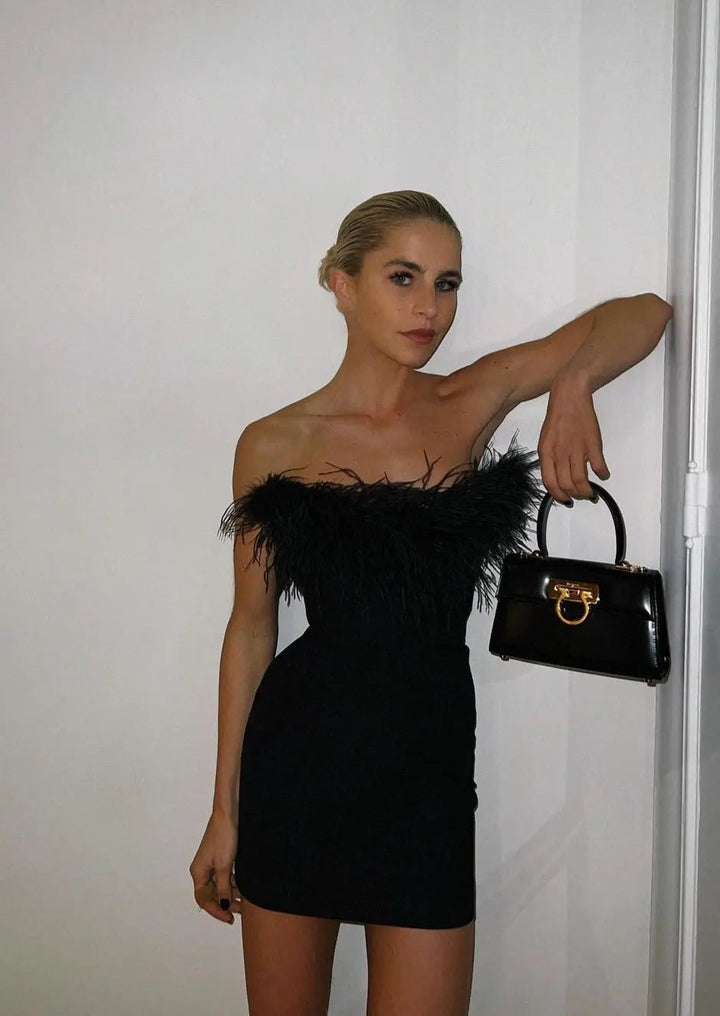 Elegant black off-shoulder mini dress for women. Perfect party, cocktail, or evening wear. Glamorous & stylish.