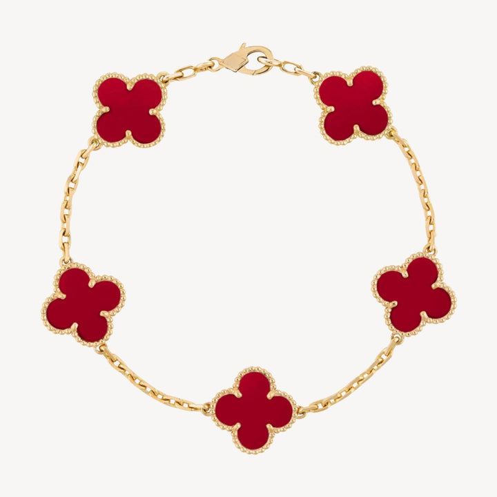 Elegant clover charm bracelet with polished black agate inlays and a gold and silver-tone chain for sophisticated style.