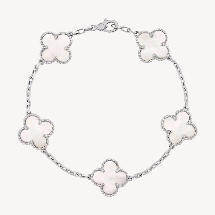 Elegant clover charm bracelet with polished black agate inlays and a gold and silver-tone chain for sophisticated style.
