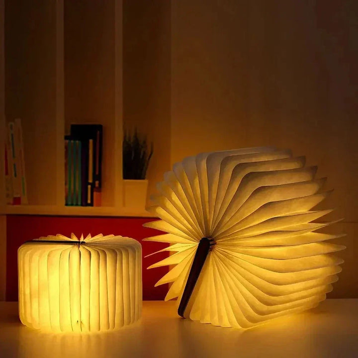 "Elegant foldable LED book lamp, warm white light, 360-degree design, portable for home or travel, wood and paper material."