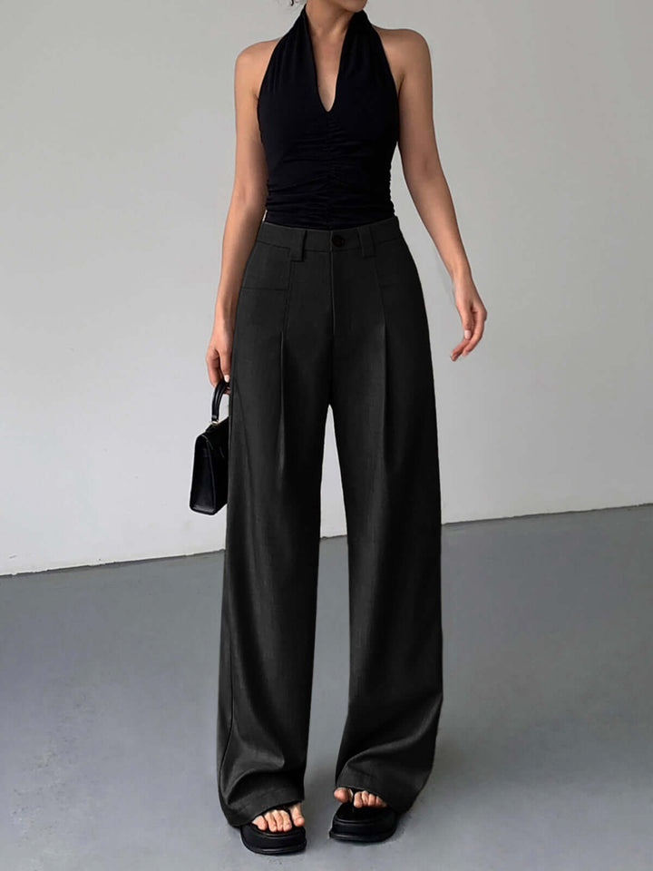 Model wearing elegant high-waisted wide-leg trousers, showcasing chic style & comfortable fit for modern fashion.
