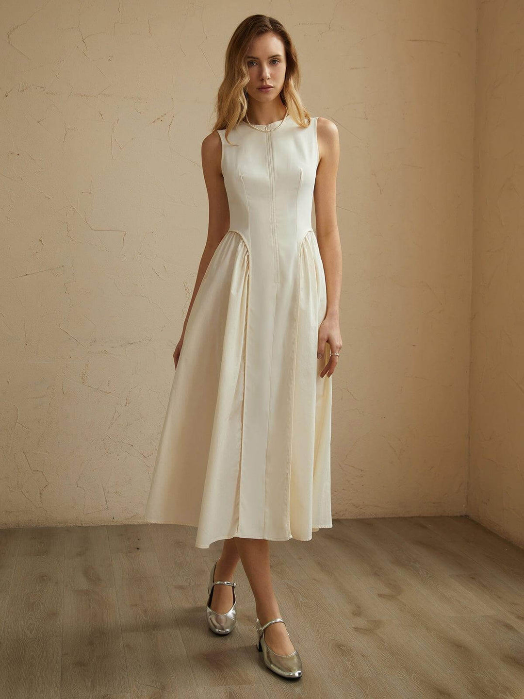 Women's flowing off-white pleated midi dress, offering elegant comfort for summer or formal wear.