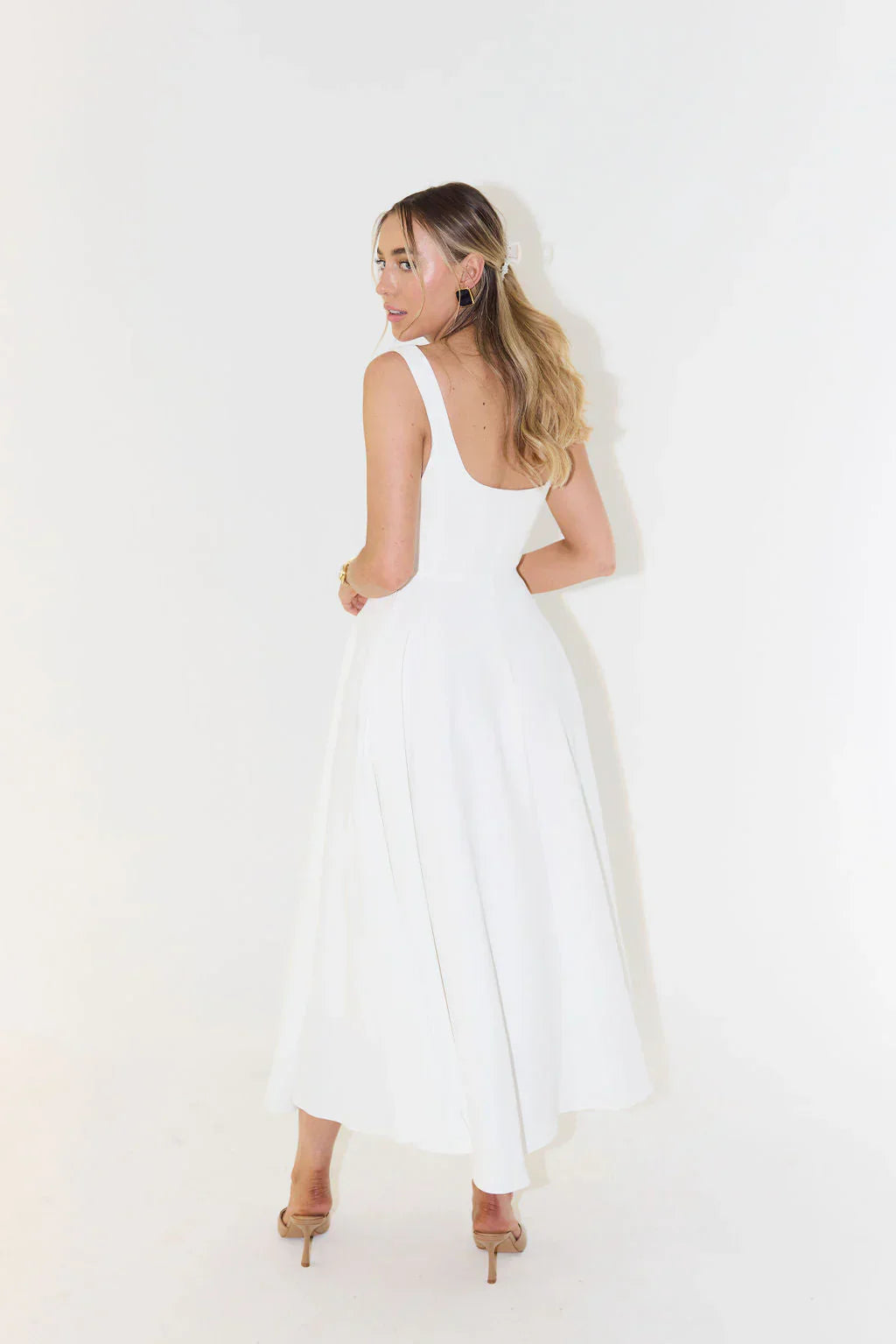 Sleeveless white midi cocktail dress for women. Features an elegant square neck & flared skirt, ideal for summer parties.