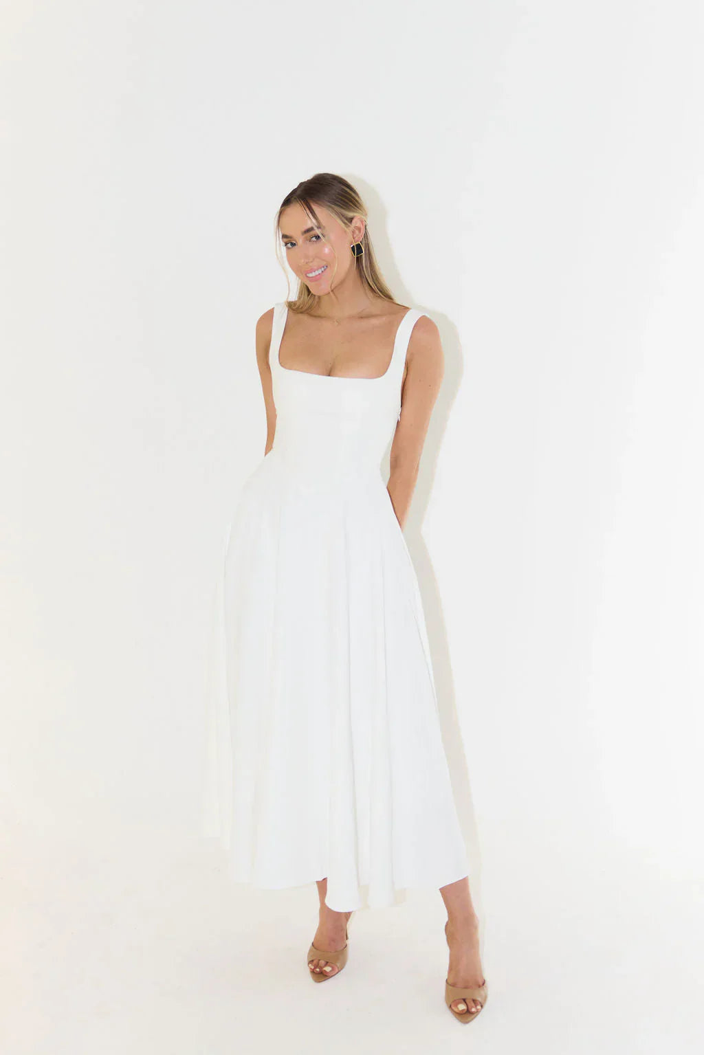 Formal white women's midi dress. Elegant sleeveless cocktail dress with a flattering square neck and flared skirt for events.