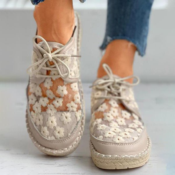 Fashionable women's white lace-up sneakers, adorned with elegant floral embroidery for comfort.