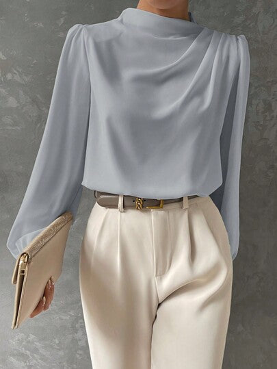 Women's versatile bishop sleeve blouse styled for business casual and elegant evening fashion. Long sleeve top.