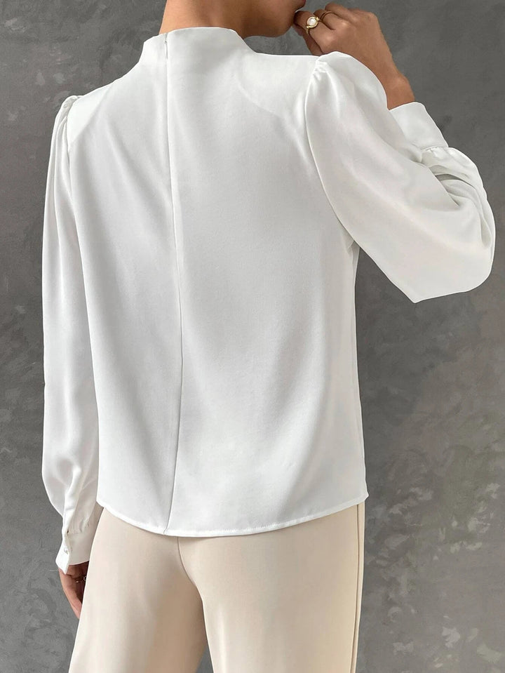 Draped neckline detail of a stylish women's blouse. Elegant top, ideal for office wear or an evening outfit.