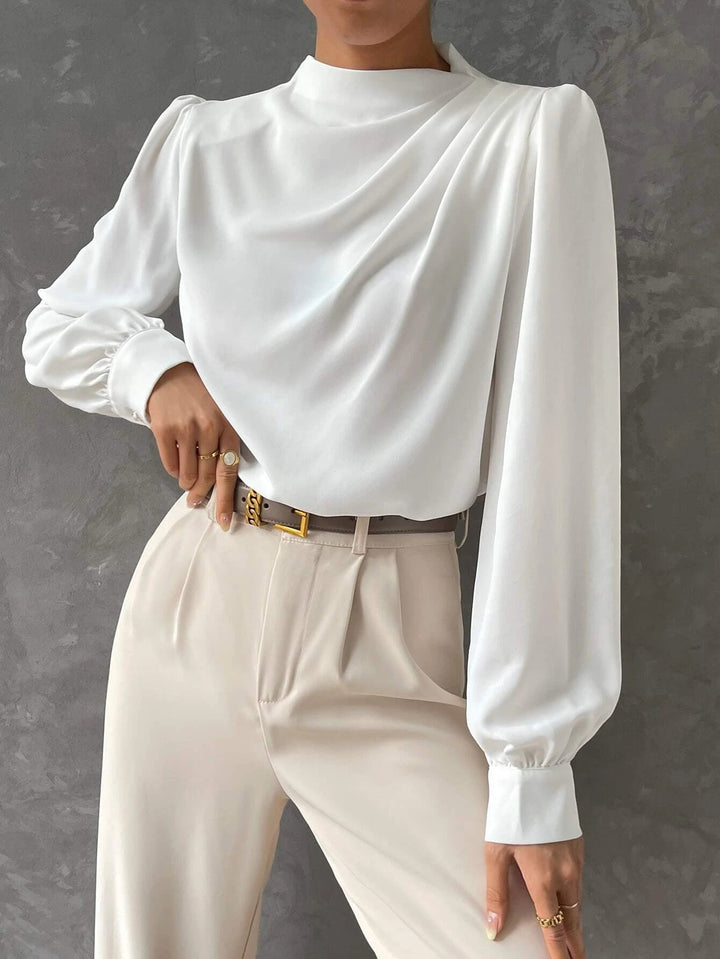 White women's stylish bishop sleeve blouse. Elegant long sleeve top with draped neckline, perfect for chic fashion.